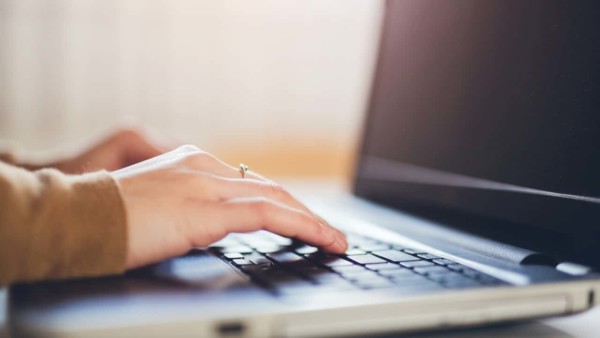 Image of someone typing on a laptop keyboard.