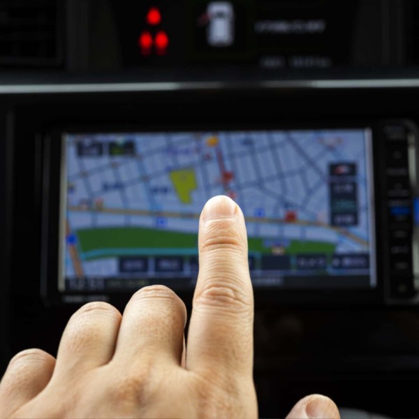 Image of a hand pointing to a gps navigation screen.