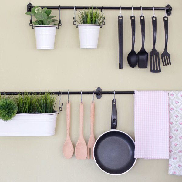 hanging pots and pans on floating shelves on kitchen wall