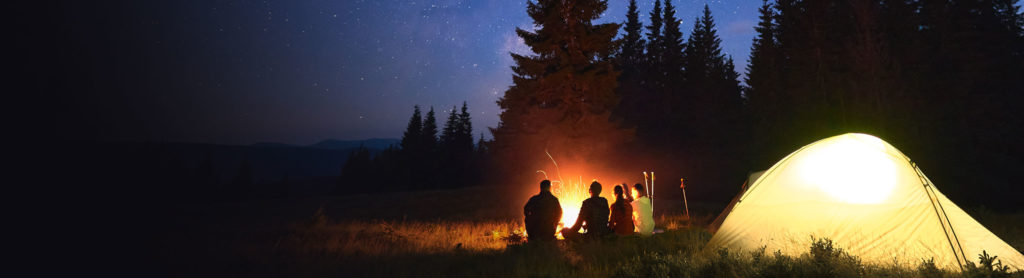 Image of a group of people camping outside at night.