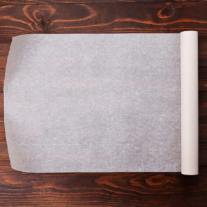 Parchment paper rolled out on a wooden table