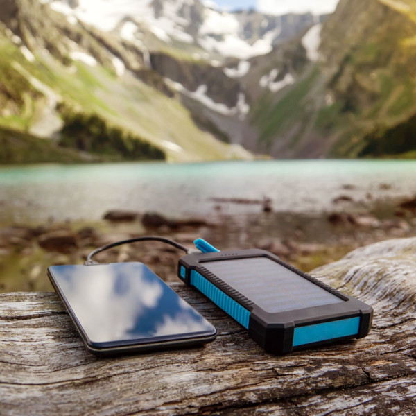 phone charging with a remote charger in front of mountains and a lake