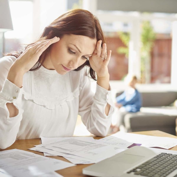 Woman looking at financial papers so she can manage her finances