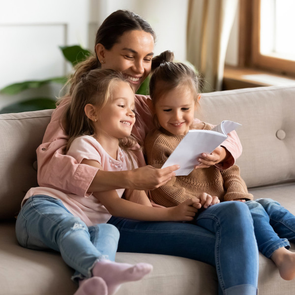 Image of a mom reading book to two girls.
