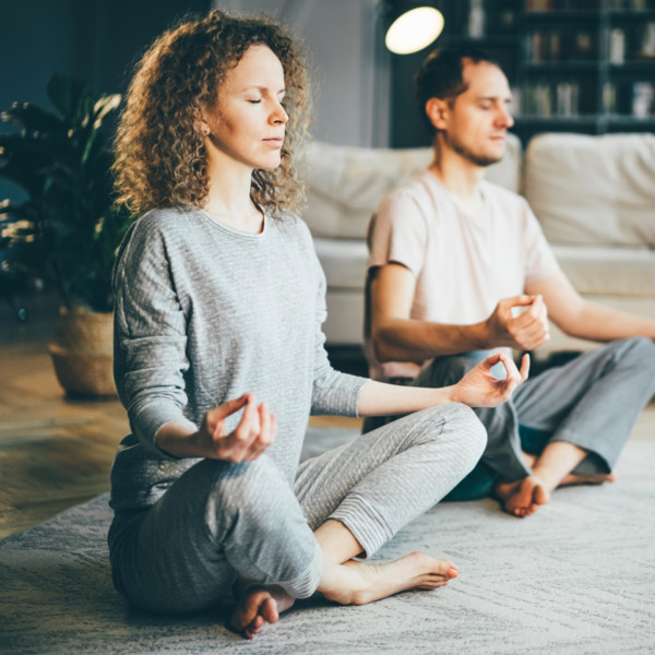 Couple meditating in living room