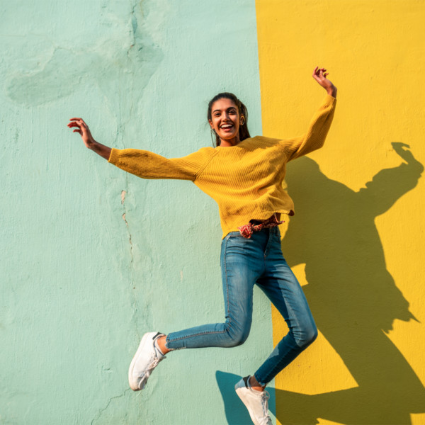 Image of someone jumping in front of a green and yellow wall.
