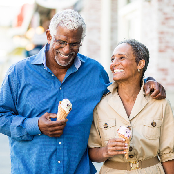 Image of an older couple on a date walking with ice cream.