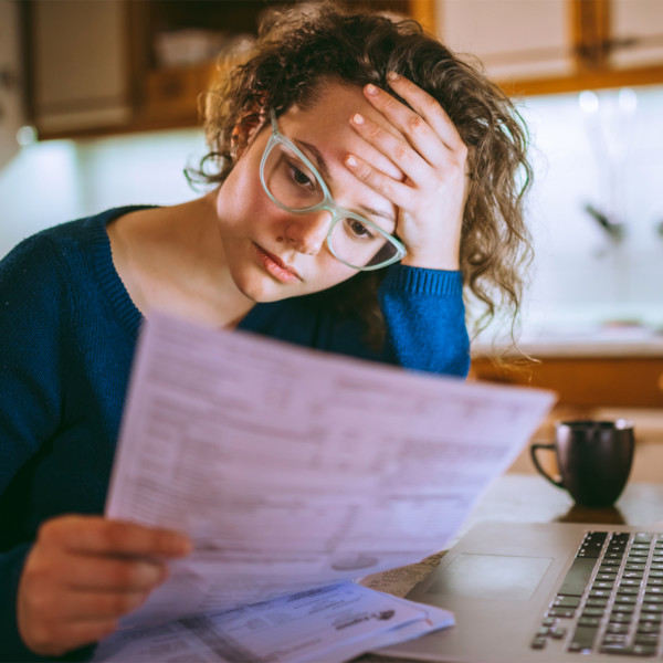 woman stressed from reviewing debt papers as she tried to manage debt