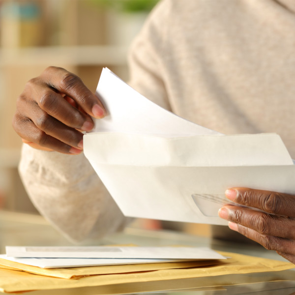 woman mailing an envelope to help manage debt
