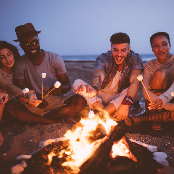 Image of friends roasting marshmallows on a fire