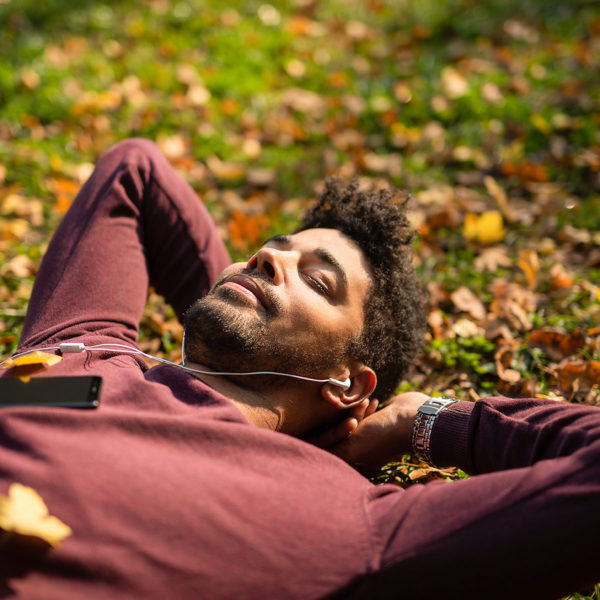 Image of someone laying in the grass listening to music