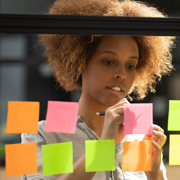 Image of someone writing on sticky notes