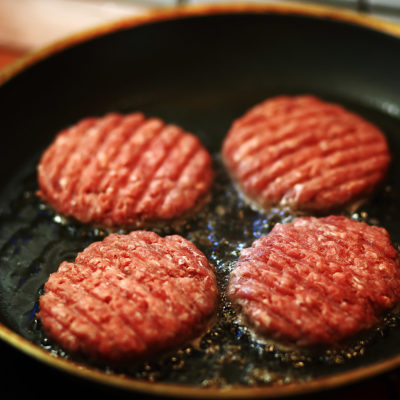 Image of burgers being cooked in a pan