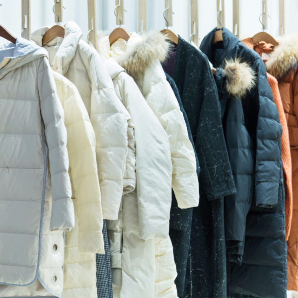 Winter coats hanging on a clothing rod as part of a capsule wardrobe